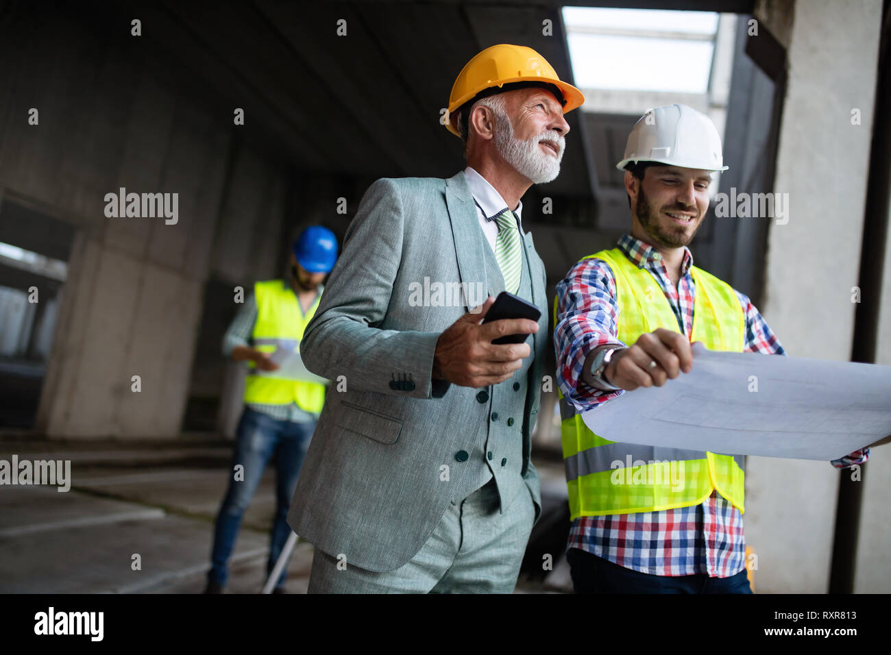 Engineer and construction site manager dealing with blueprints and plans Stock Photo