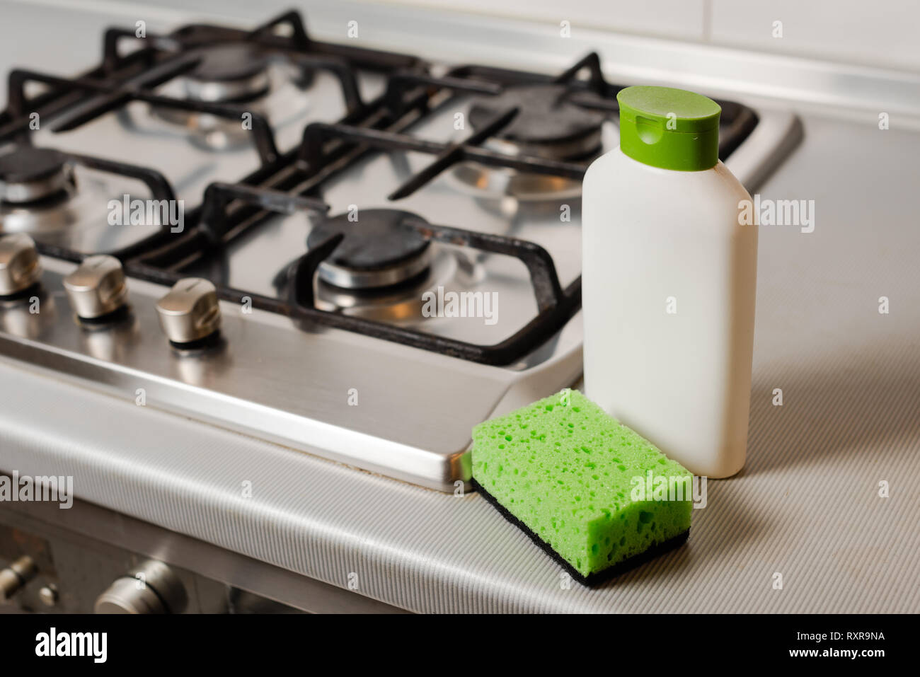 Cleaning Detergent Product And Sponge At Gas Stove Stock Photo