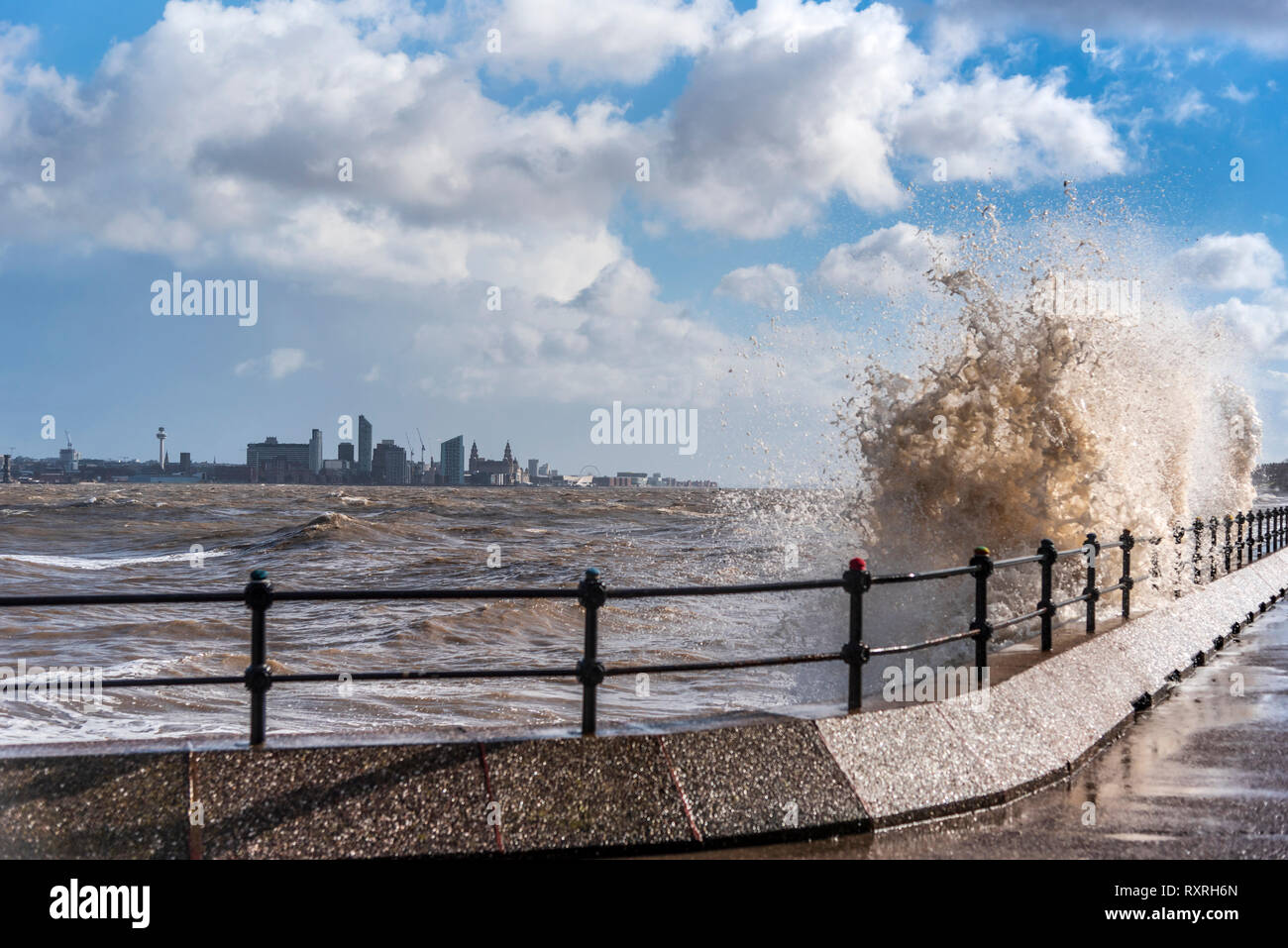New Brighton, Merseyside, UK. 10th Mar 2019. Waves batter the Egremont promenade on the river Mersey  with Liverpool skyline in the background during the high winds. Credit: John Davidson/Alamy Live News Stock Photo