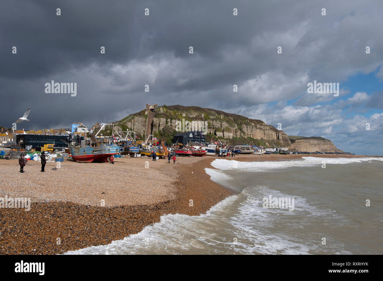 Hastings, East Sussex, UK. 10th March 2019. Hastings fishing boats pulled up high on the Stade beach, protected by the new sea defences and out of reach of the rough sea driven by onshore gales. Hastings has the largest beach-launched commercial fishing fleet in Europe. Stock Photo