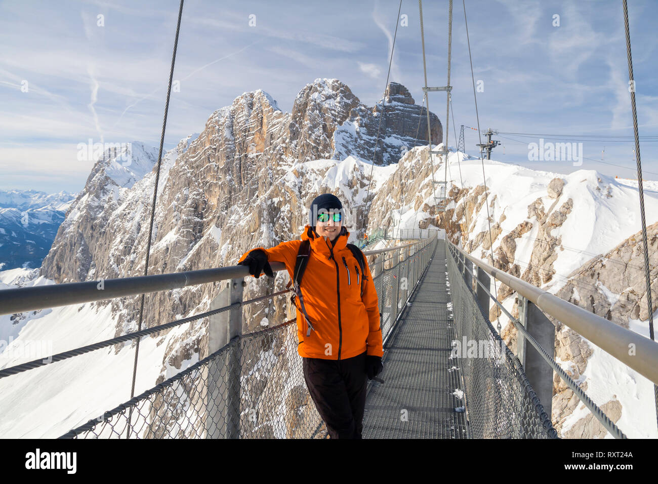 man walking across rope bridge on Dachstein mountain Stock Photo - Alamy