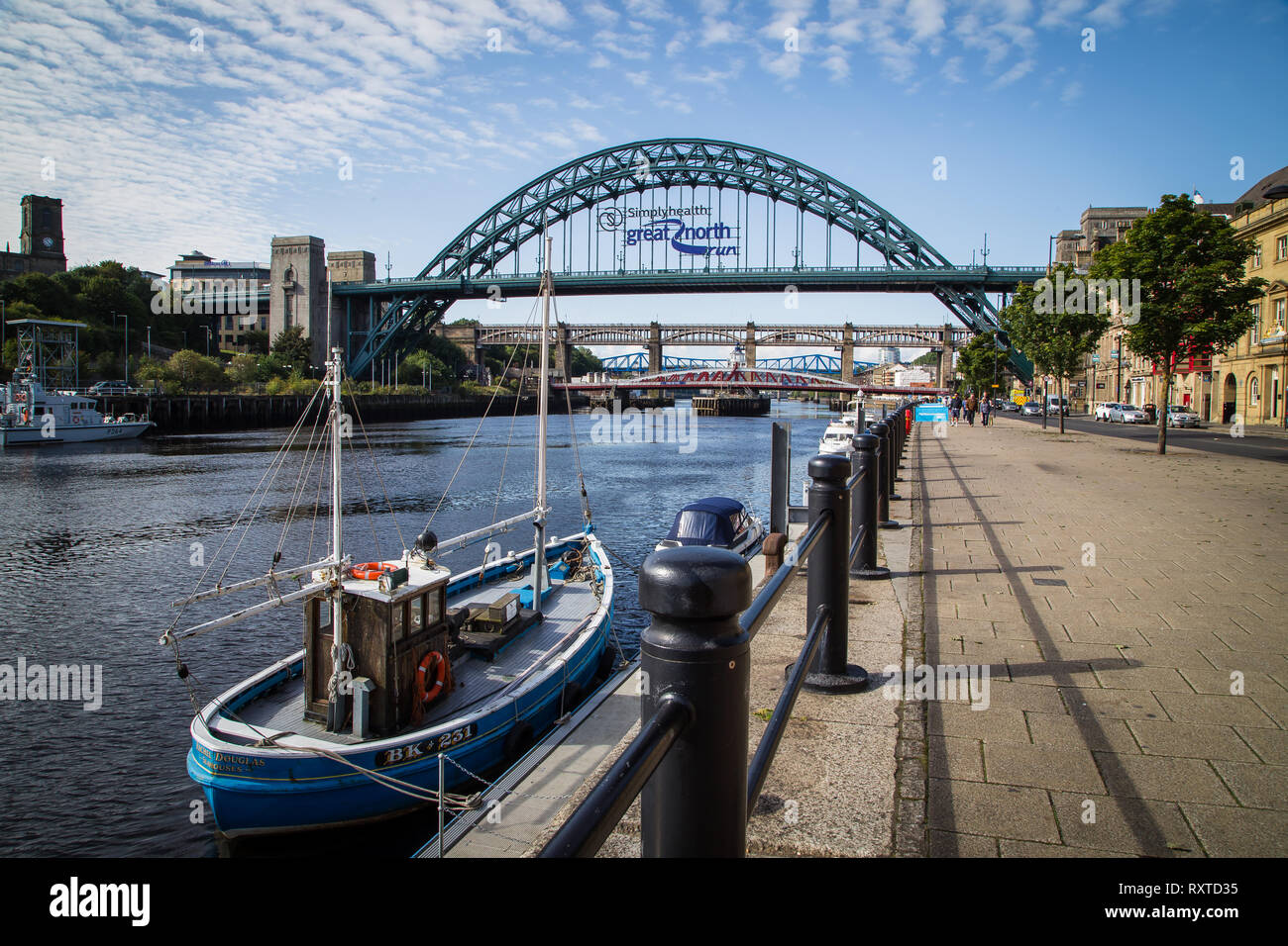 Newcastle,UK. Tyne bridge with great north run sign and a boat moored up in the foreground Stock Photo