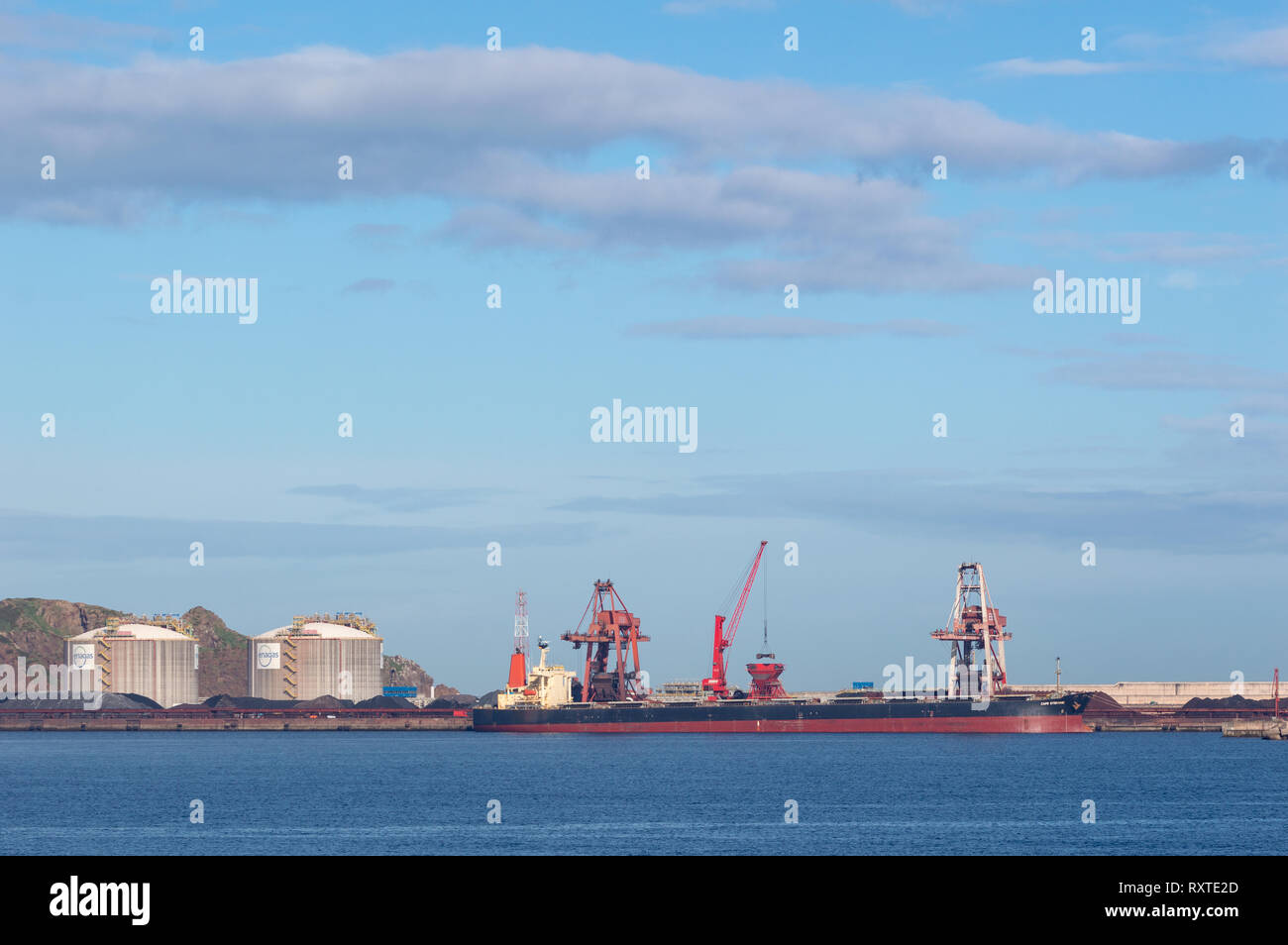 Gijón, Asturias, Spain - march 07 2019 Coal cargo ship moored in port with lifting cargo cranes, ships and grain Stock Photo