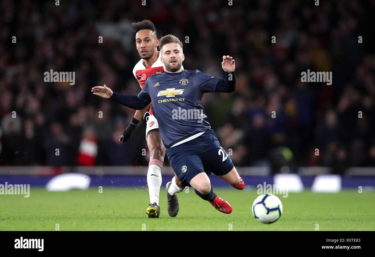 Arsenal's Pierre-Emerick Aubameyang (left) and Manchester United's Luke Shaw battle for the ball during the Premier League match at the Emirates Stadium, London. Stock Photo