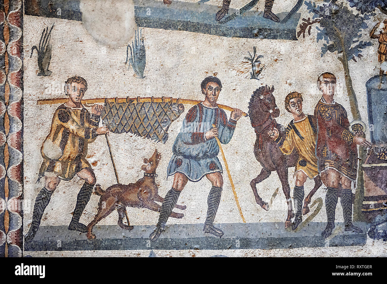 Hunters carrying a dead wild boar. Roman mosaic floor of the Room of The Small Hunt, no 25 - Roman mosaics at the Villa Romana del Casale ,  circa the Stock Photo