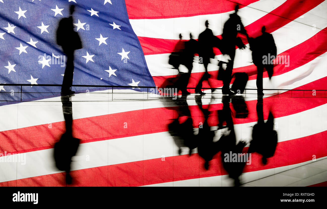 Businessmen at airport departure gate against USA flag background. Immigration, trade, Covid 19, Coronavirus travel restrictions... concept Stock Photo