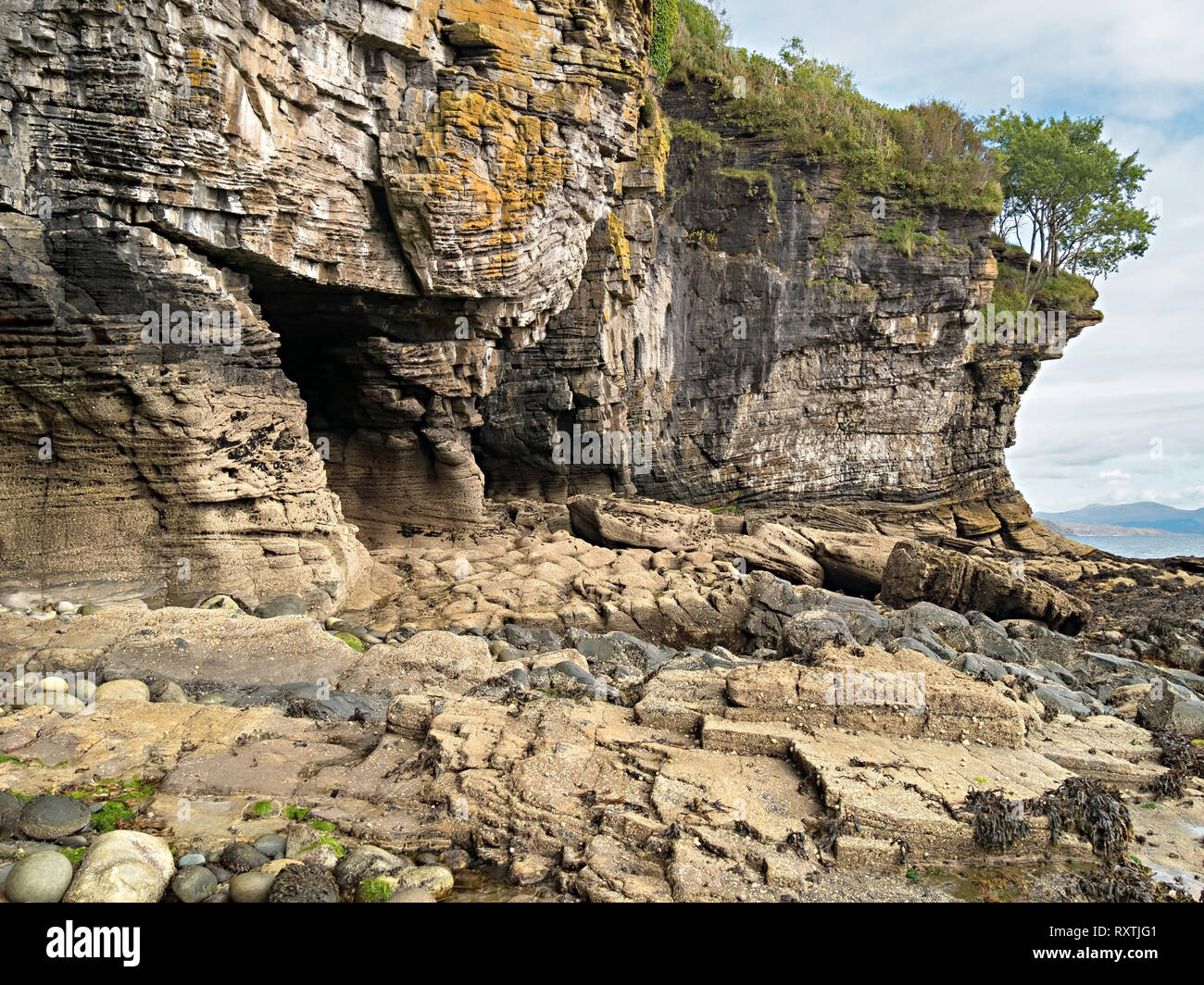 Eroded rocks sea cliffs and sea caves on shoreline near Elgol on the Scottish Island of Skye, Scotland, UK Stock Photo