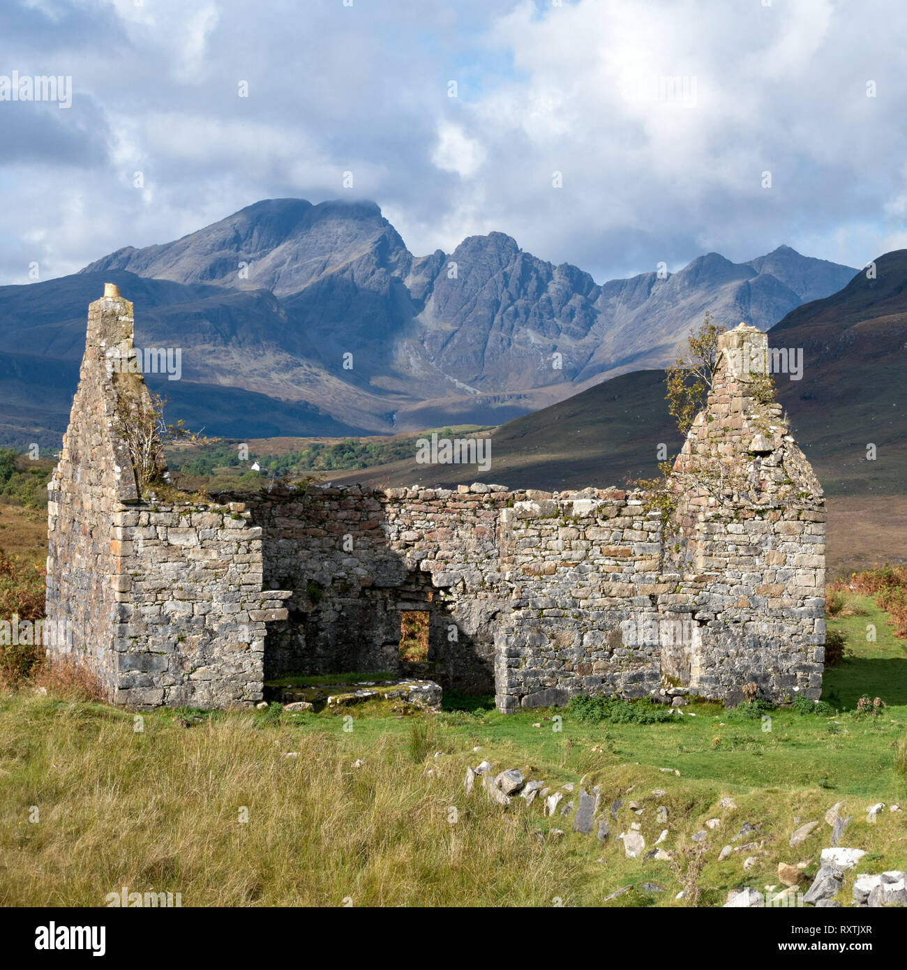 Ruined old manse house with Blaven in the Black Cuillin mountains in the distance, Kilchrist, Isle of Skye, Scotland, UK Stock Photo