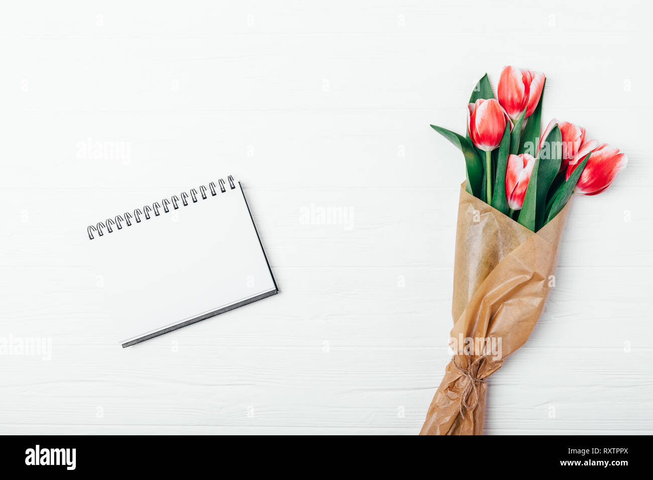 Flat lay composition blank notepad template next to beautiful romantic ...
