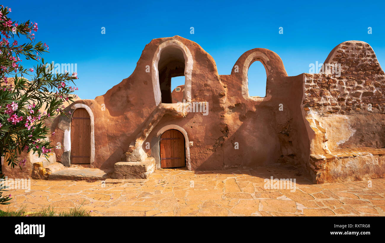 The northern Sahara ghorfa storage graneries of the traditional Berber mud brick fortified Ksar of Hedada or Hadada, near Tetouin, Tunisia, the settin Stock Photo