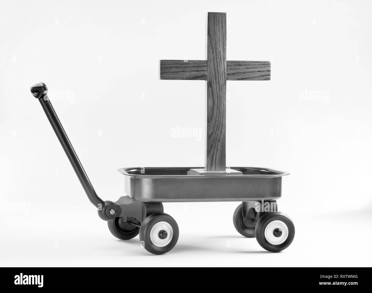 Hauling the old wooden cross in a little red wagon in black and white. Stock Photo