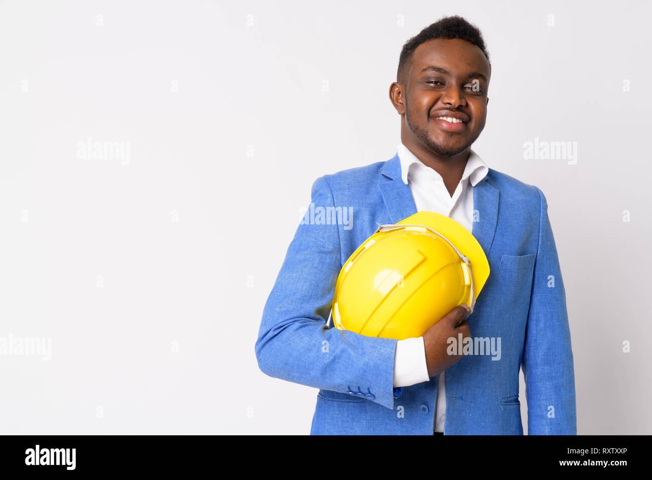 Portrait of happy young African businessman holding hardhat Stock Photo