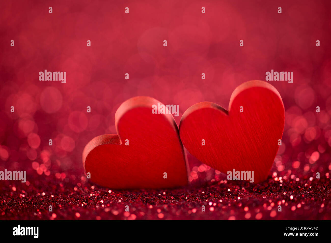 Two red hearts on glitter background in love concept Stock Photo - Alamy