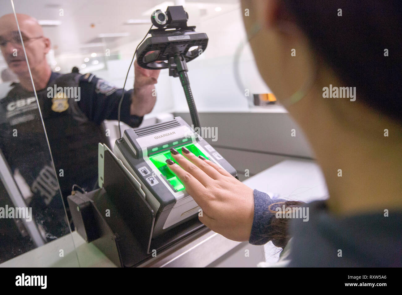 United States Customs and Border Protection (USCBP) scan the finger prints of arrivals at Miami International Airport in Miami, Florida. See more information below.; Stock Photo