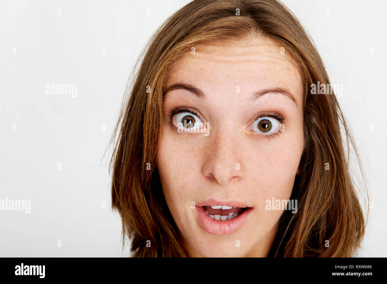 Shocked face of redhead woman on white background. Stock Photo