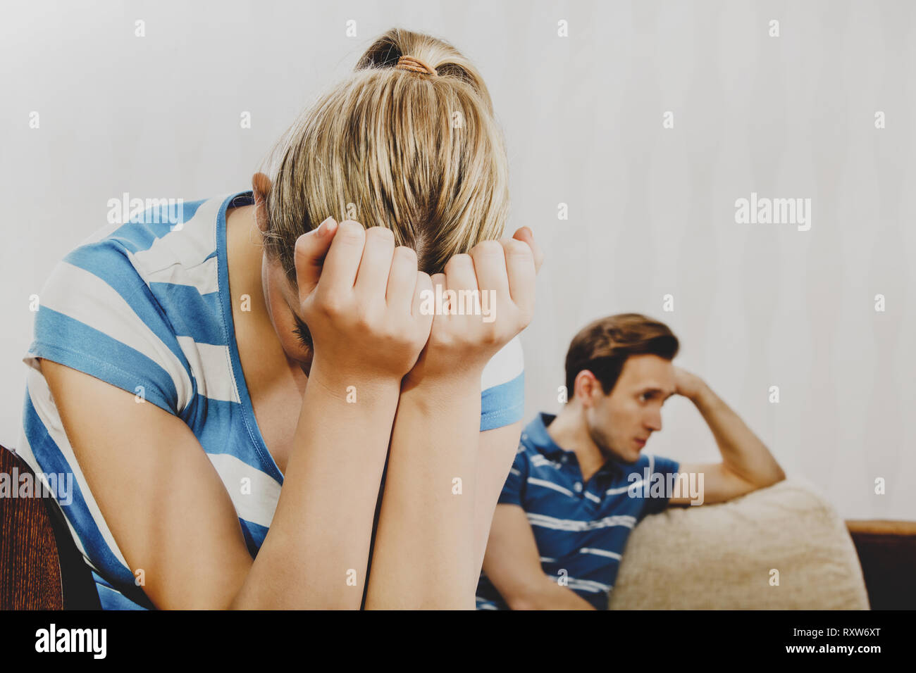 Couple after quarrel. Woman is crying and man takes offense. Stock Photo