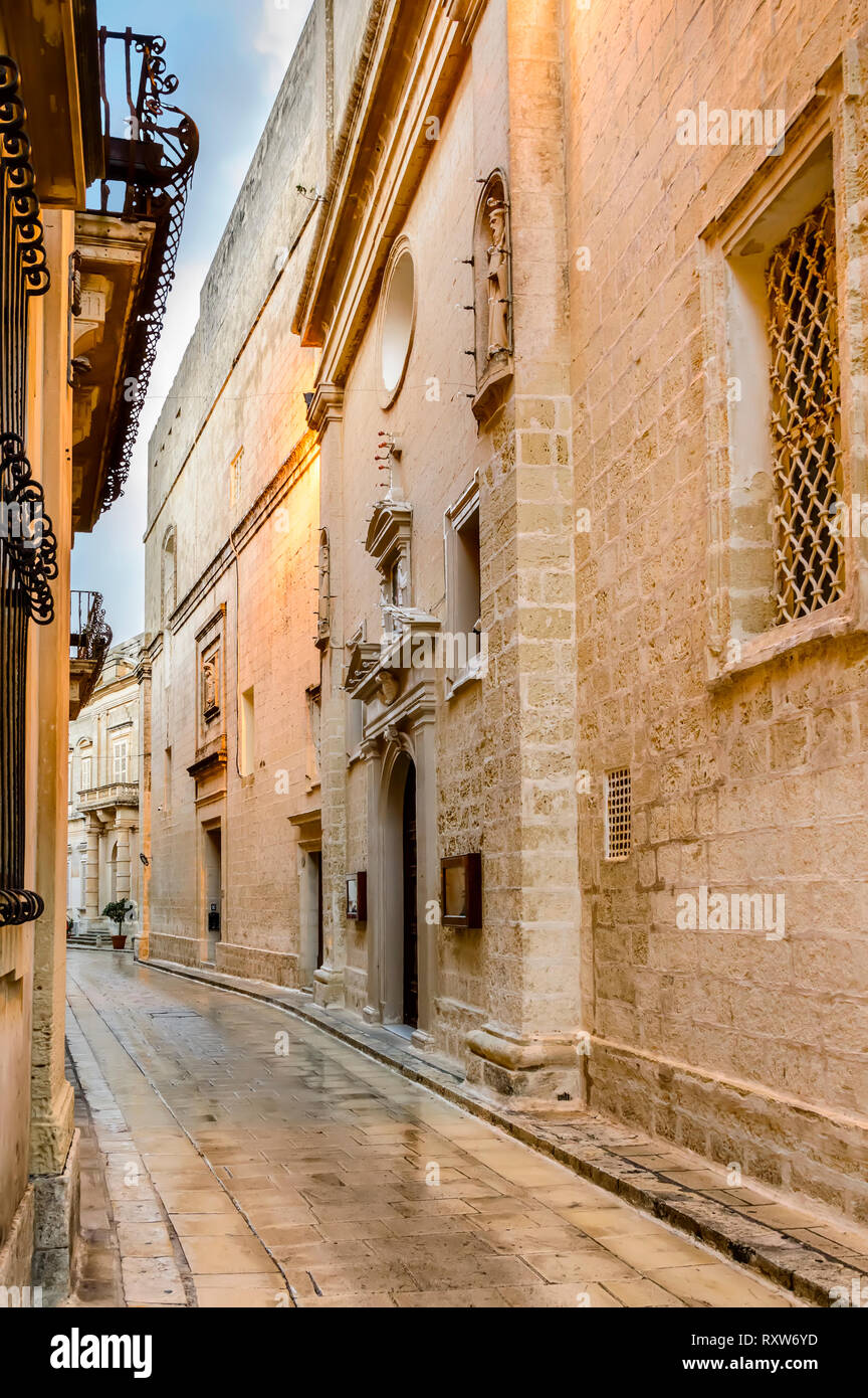 Mdina, Malta: narrow street paved with setts with limestone walls. Medieval Maltese architecture Stock Photo
