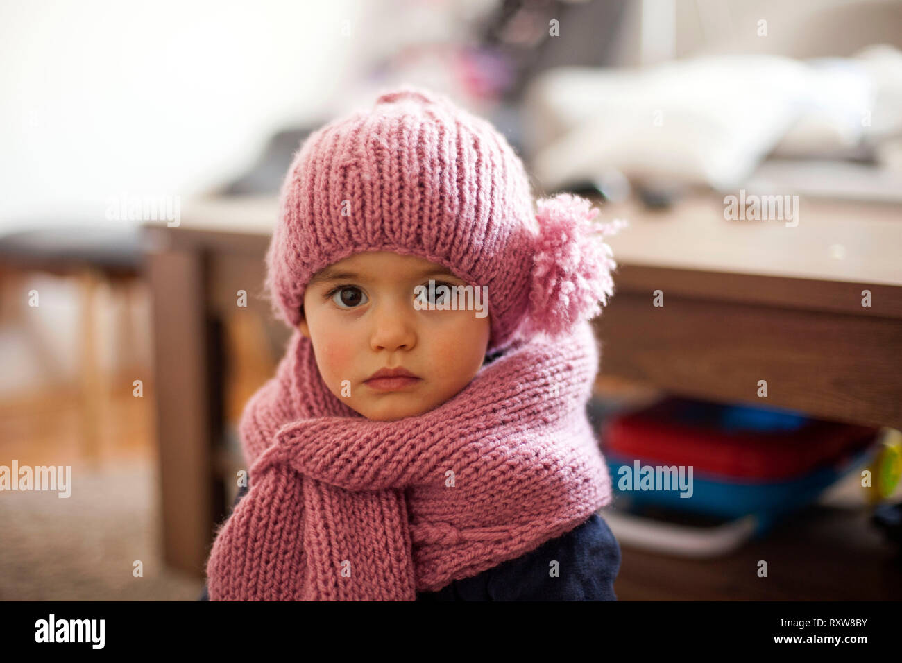 Cute little baby girl wearing purple woolen cap and warm scarf Stock Photo
