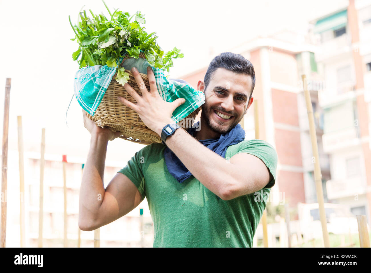 young farmer carrying a basket of vegetables in his garden Stock Photo ...