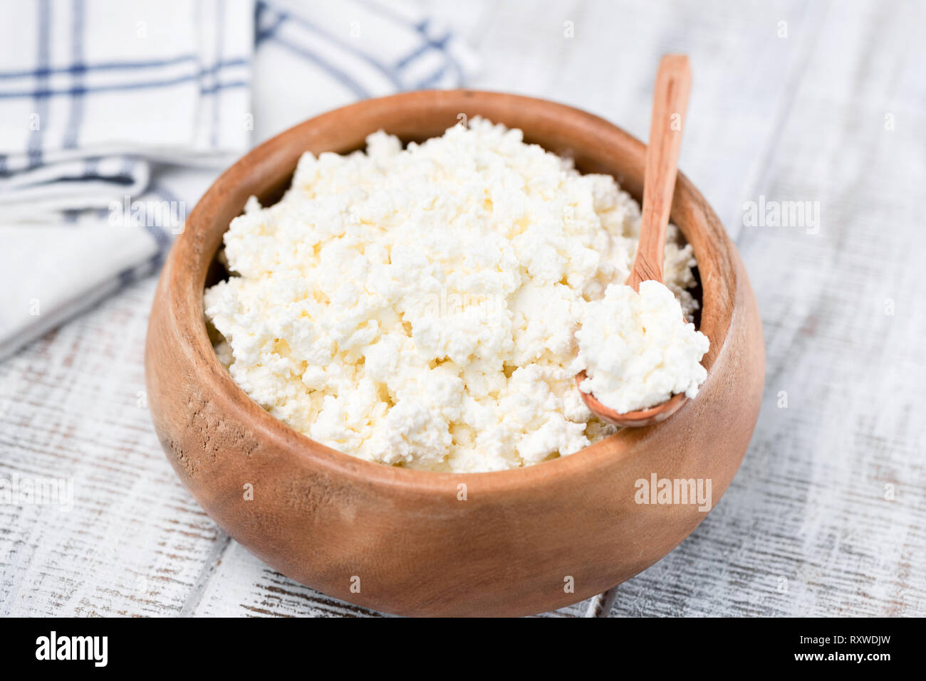 Cottage cheese or tvorog in wooden bowl on white background. Rich in Calcium dairy product for sporty healthy lifestyle Stock Photo