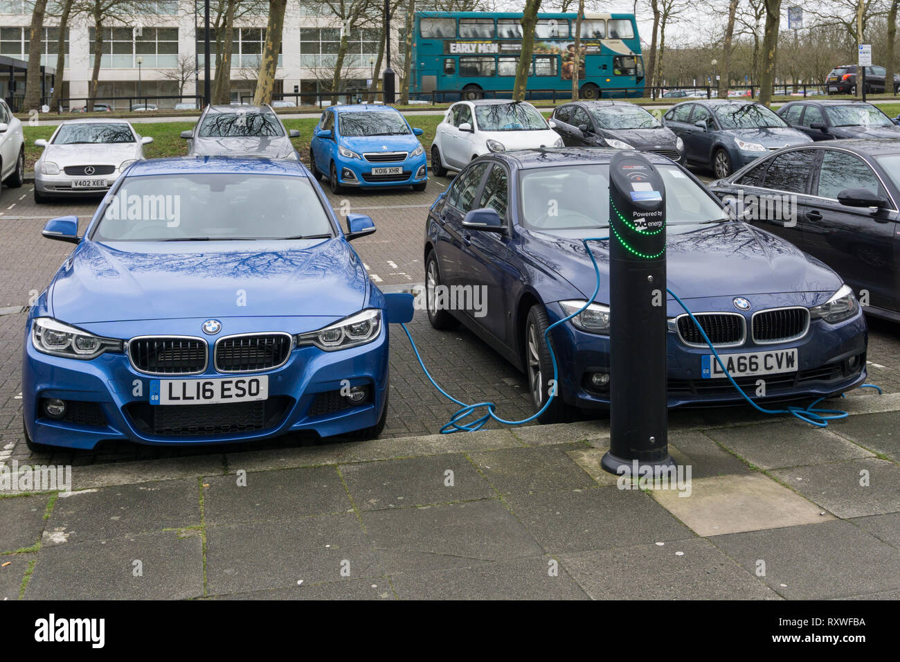 Two electric BMW cars being charged in Milton Keynes town centre, Buckinghamshire, UK Stock Photo
