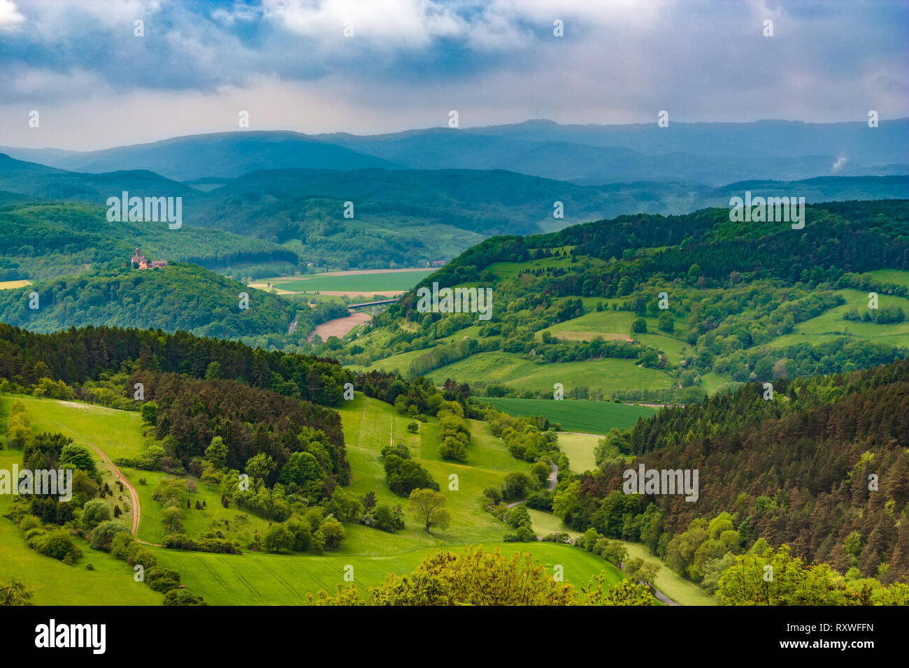 Lovely landscape view of the Werra Valley, the Hessian low mountains and the Ludwigs Castle on the far left. Taken from the famous Hanstein Castle, on... Stock Photo