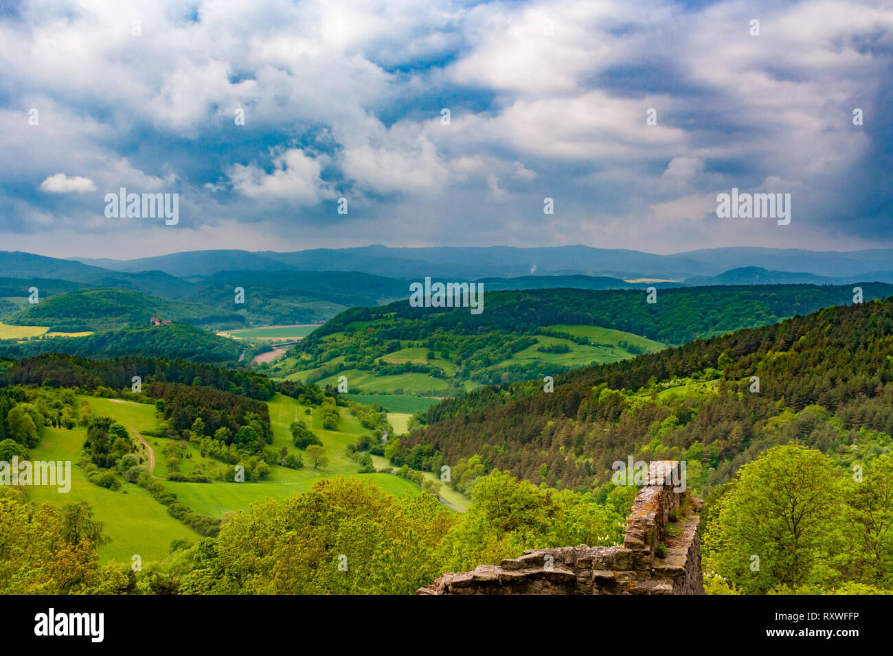 The famous ruins of Hanstein Castle in Central Germany is overlooking the Werra Valley surrounded by beautiful woodland. On the far left the... Stock Photo