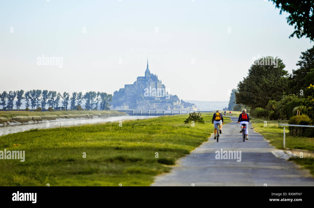 Le Mont Saint-Michel: cyclists along the Couesnon river Stock Photo