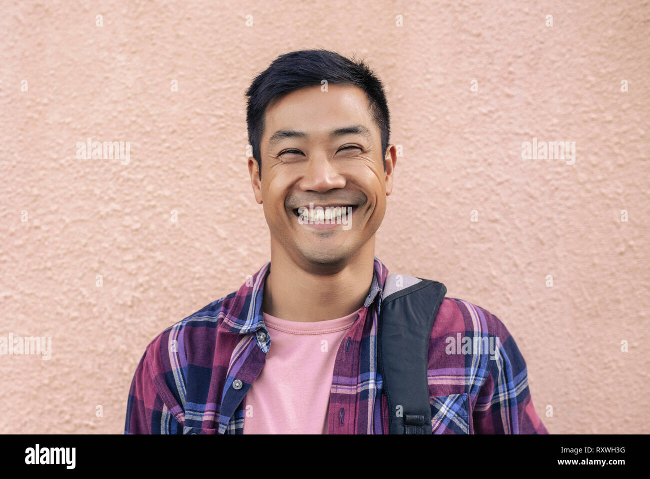 Cool happy man standing outside against the wall Stock Photo