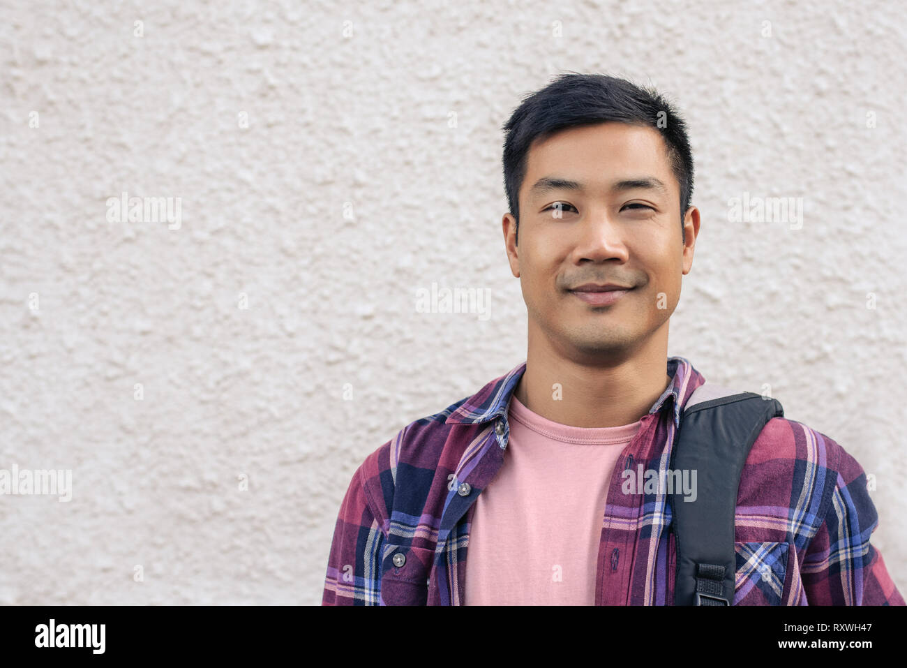 Handsome Asian man standing outside in the city Stock Photo