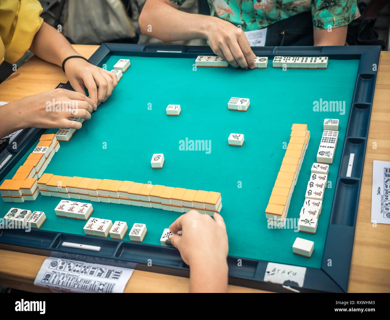 People Playing Mahjong Asian Tile-based Game. Table Gambling top view Stock Photo