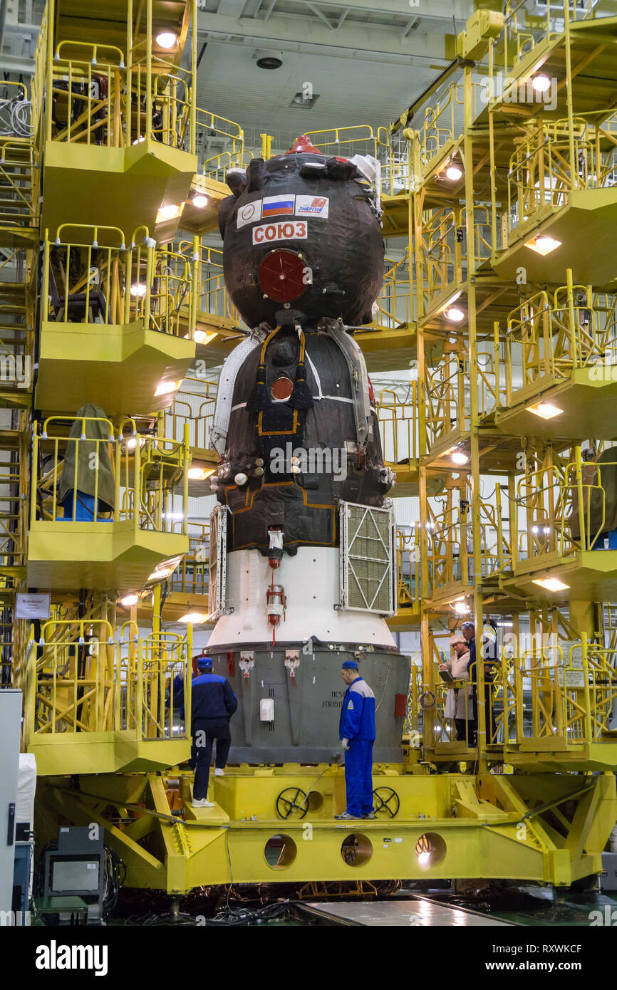 The Russian Soyuz MS-12 spacecraft is prepared for encapsulation into the nose fairing of the booster rocket in the Integration Building at the Baikonur Cosmodrome March 6, 2019 in Baikonur, Kazakhstan. The Expedition 59 crew: Nick Hague and Christina Koch of NASA and Alexey Ovchinin of Roscosmos will launch March 14th for a six-and-a-half month mission on the International Space Station. Stock Photo