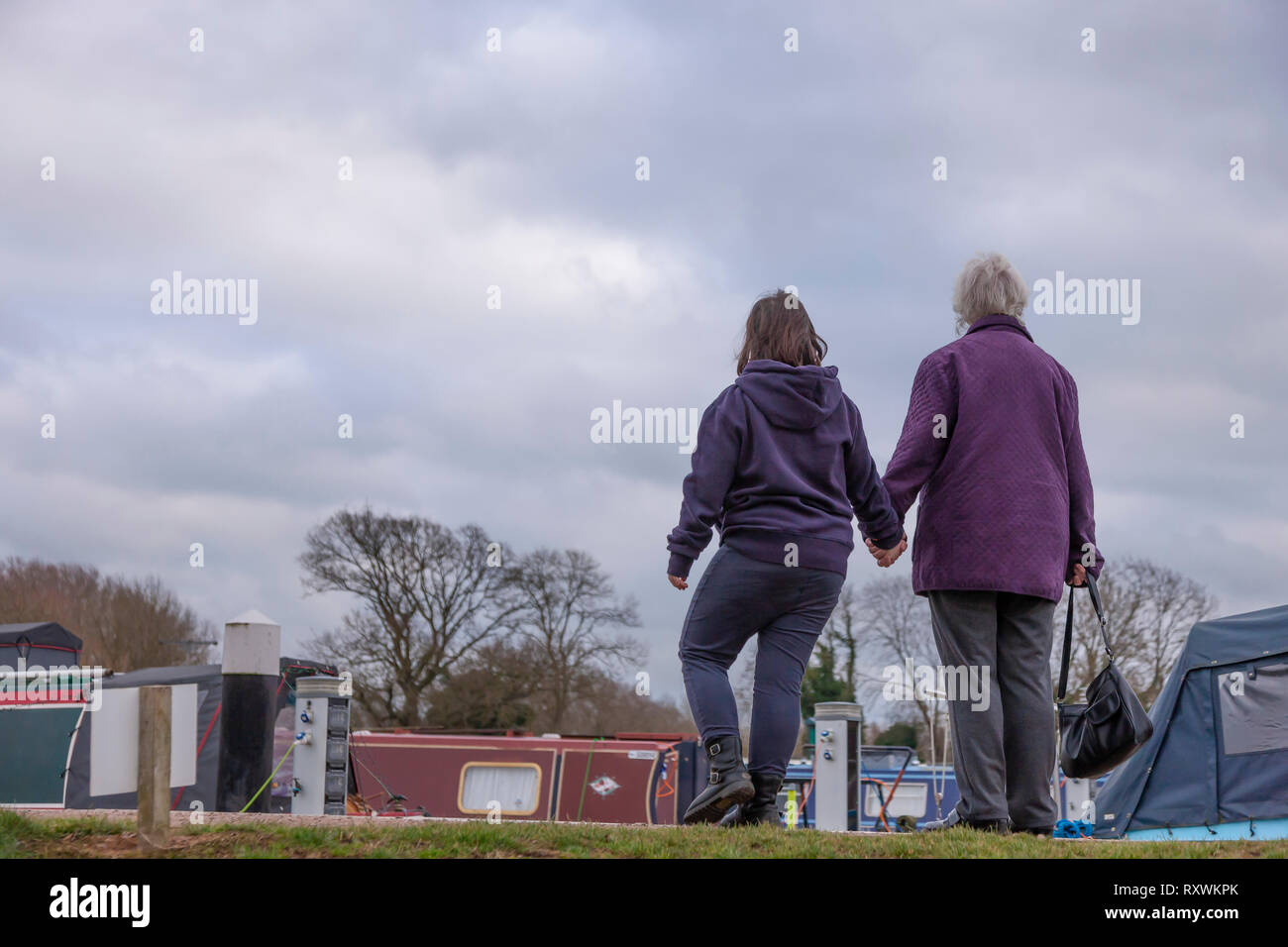 Young girl with Downs Syndrome with her Grandmother walking at White Mills Marina, Earls Barton, Northamptonshire, uk. Stock Photo