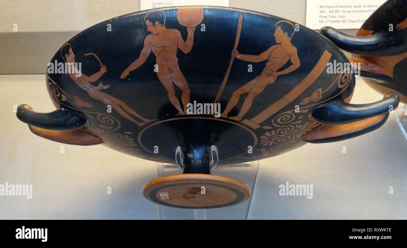 Greek red and black Krater (vase), depicting athletes training. On the left, the youth holds a strigil to scrape oil and dirt off his skin after exercise. In the middle is a young man holding a discus, on the right, a third youth, standing in front of a stele, holds two javelins. All three athletes wear victor's ribbons. Athenian, 430 BC Stock Photo