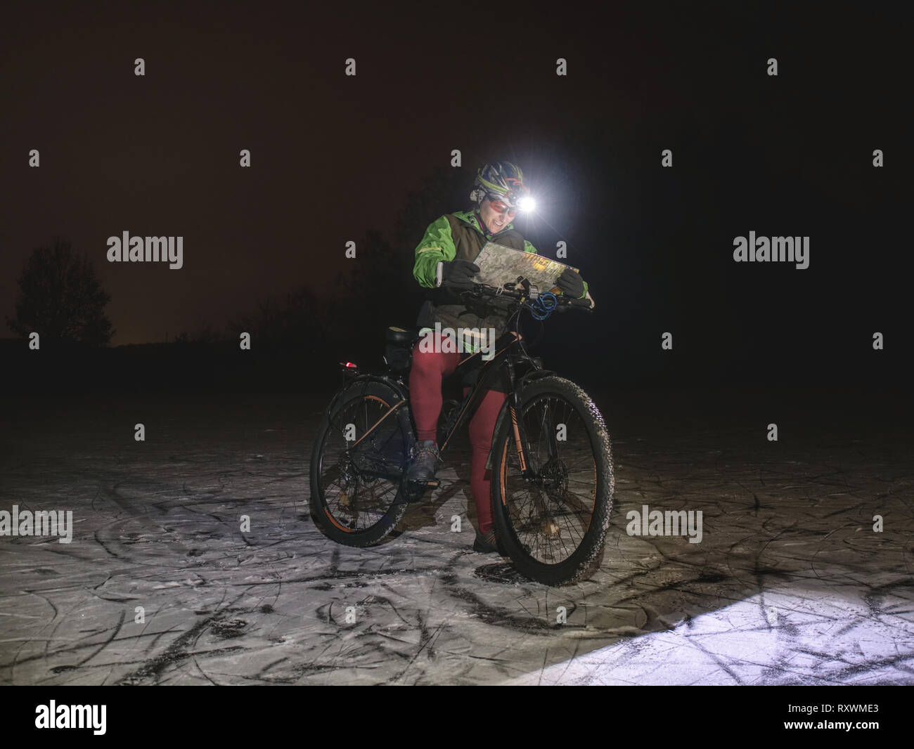 Extreme winter mtb orienteering race. Biker check the paper map 