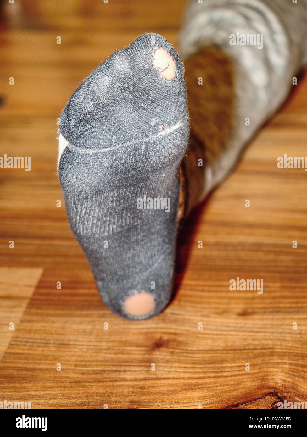 Worn out socks with holes and toes sticking out of them on old