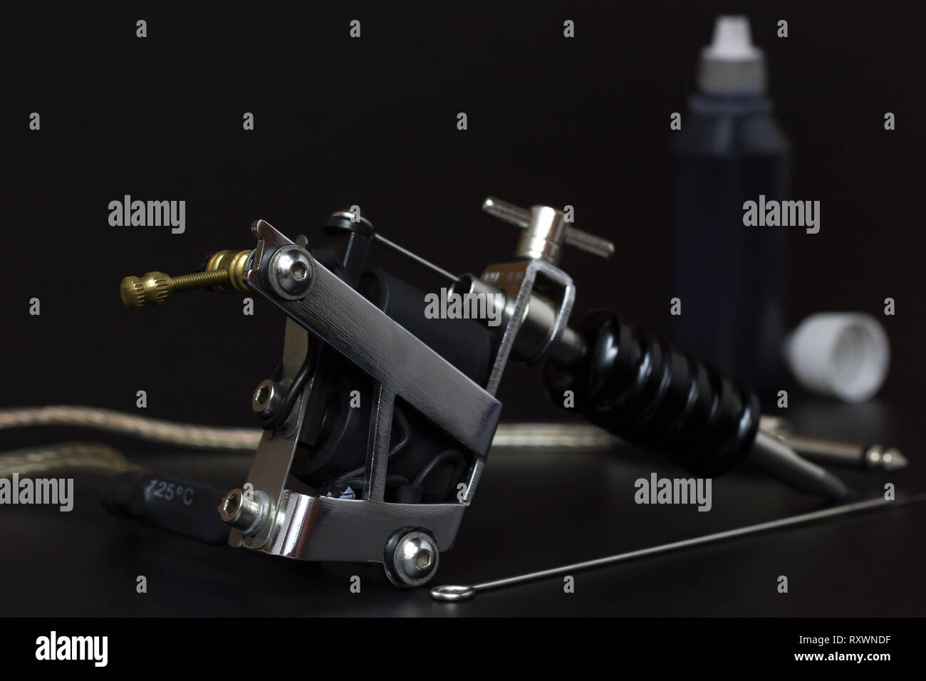 Tattoo machines and Bottles tattoo Ink in darkness. Equipment for