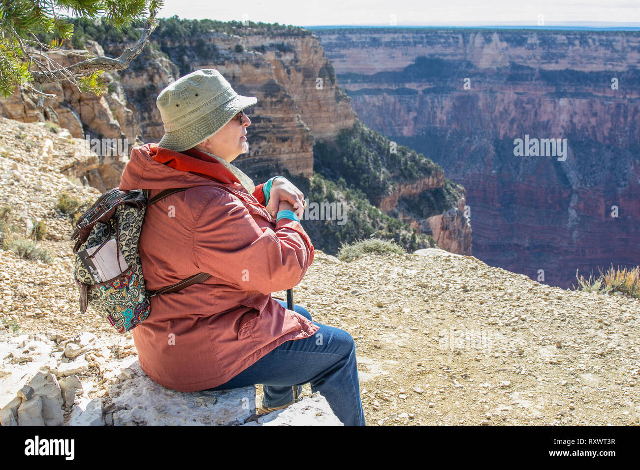 Middle age woman sitting on the edge of a cliff in Grand Canyon ...