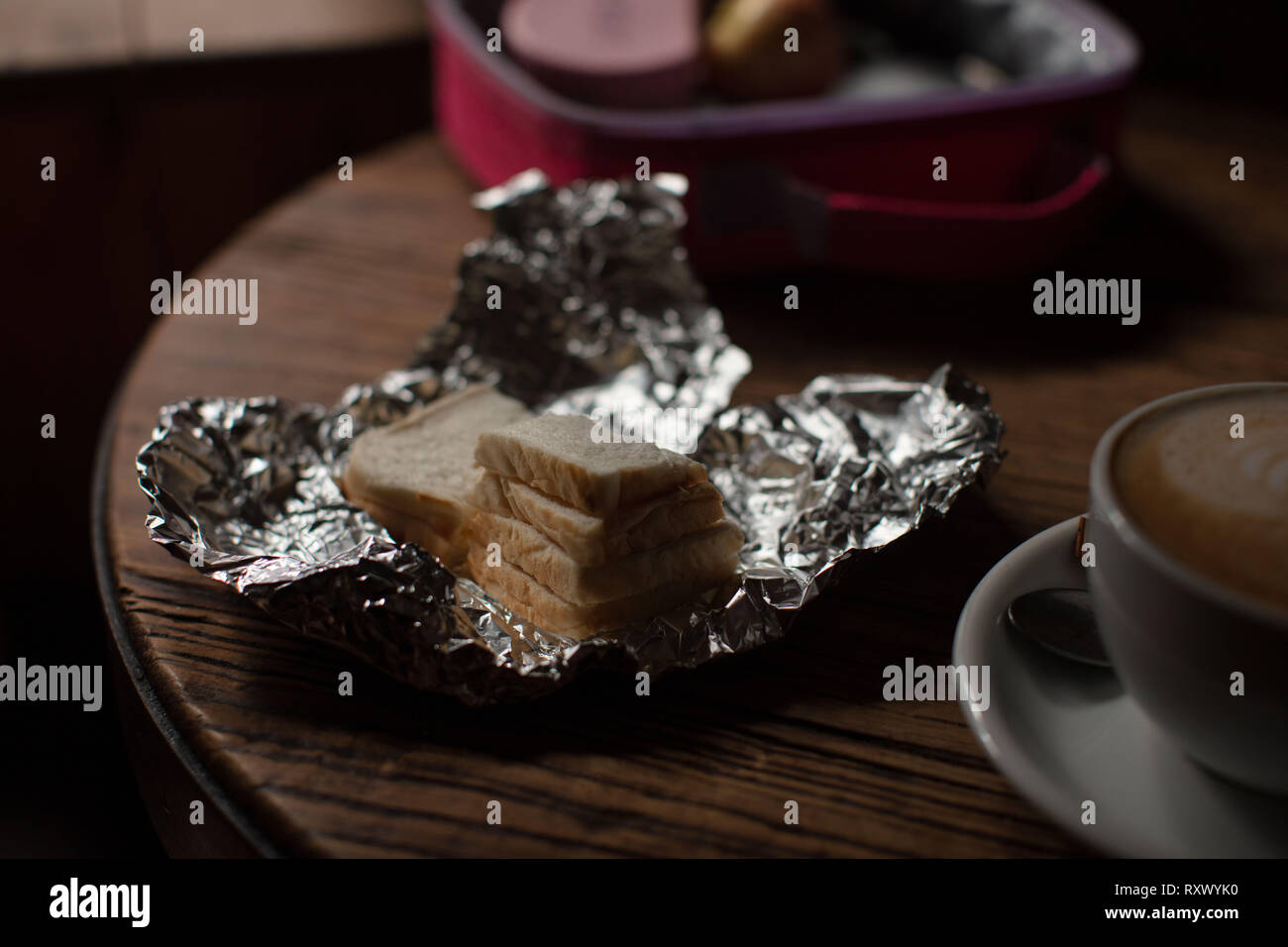 An image of a childs lunch box indoors with a relatives Coffee. Stock Photo