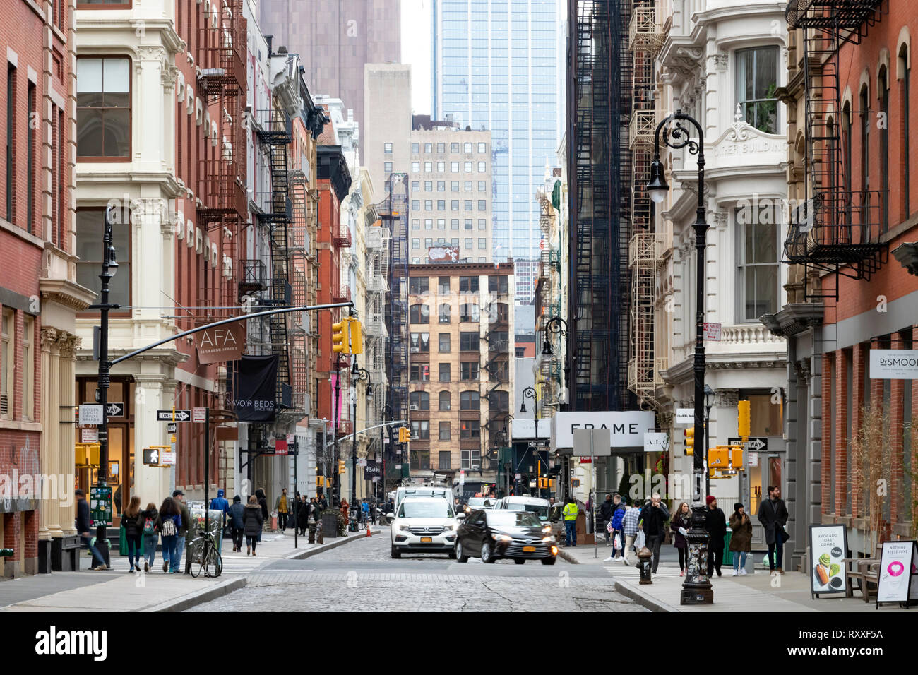 NEW YORK CITY - CIRCA 2019: Busy intersection of Broome and Greene Streets is crowded with people and cars in the SoHo neighborhood of Manhattan in NY Stock Photo