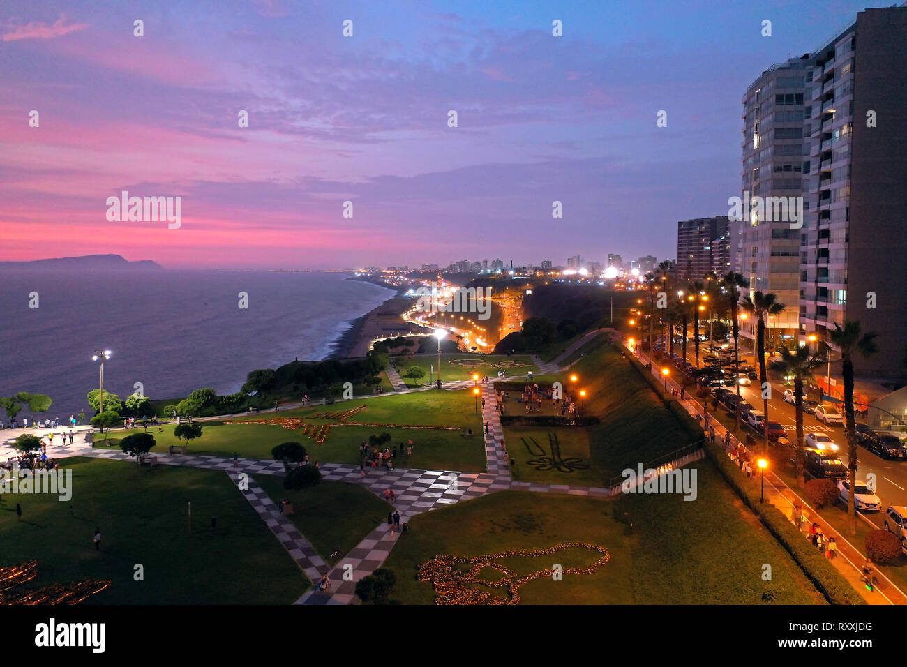 Aerial view of Maria Reiche Park at sunset with scenic seascape on the background. Tourists, families and kids playing and walking around the park at Stock Photo