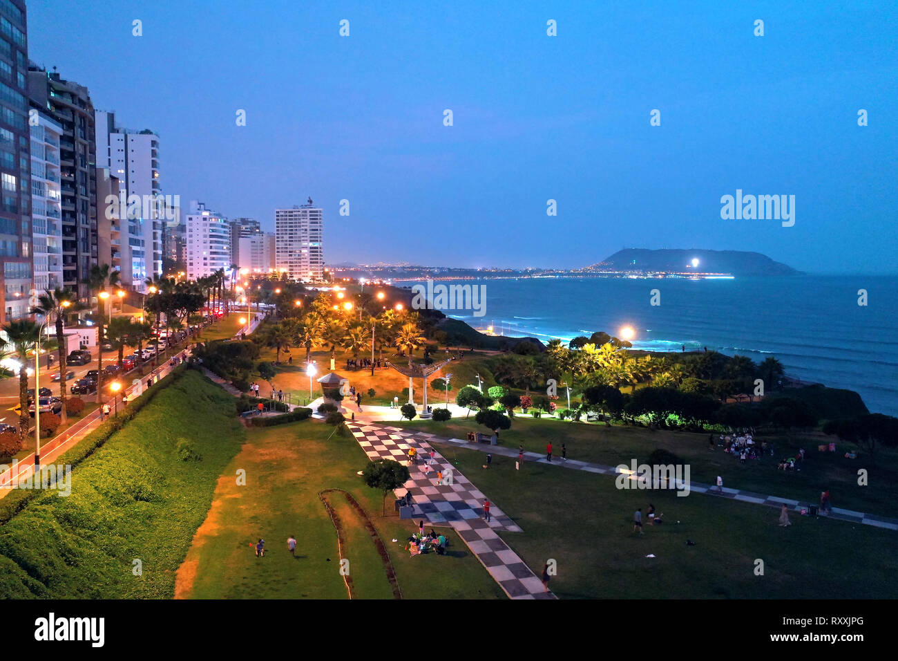 Aerial view of Maria Reiche Park at sunset with scenic seascape and Chorrillos cross in the background. Tourists, families and kids playing and walkin Stock Photo