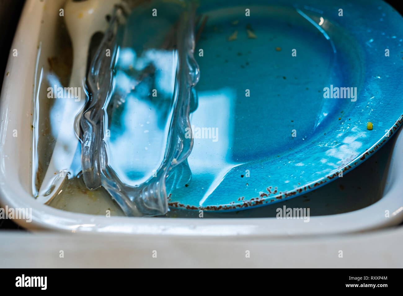 Unwashed dirty dishes soaking in a sink. Stock Photo
