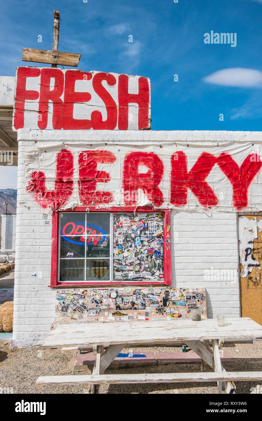 A small older white brick building along California highway 395 in the Eastern Sierras advertises the jerky it sells in huge red letters painted on th Stock Photo