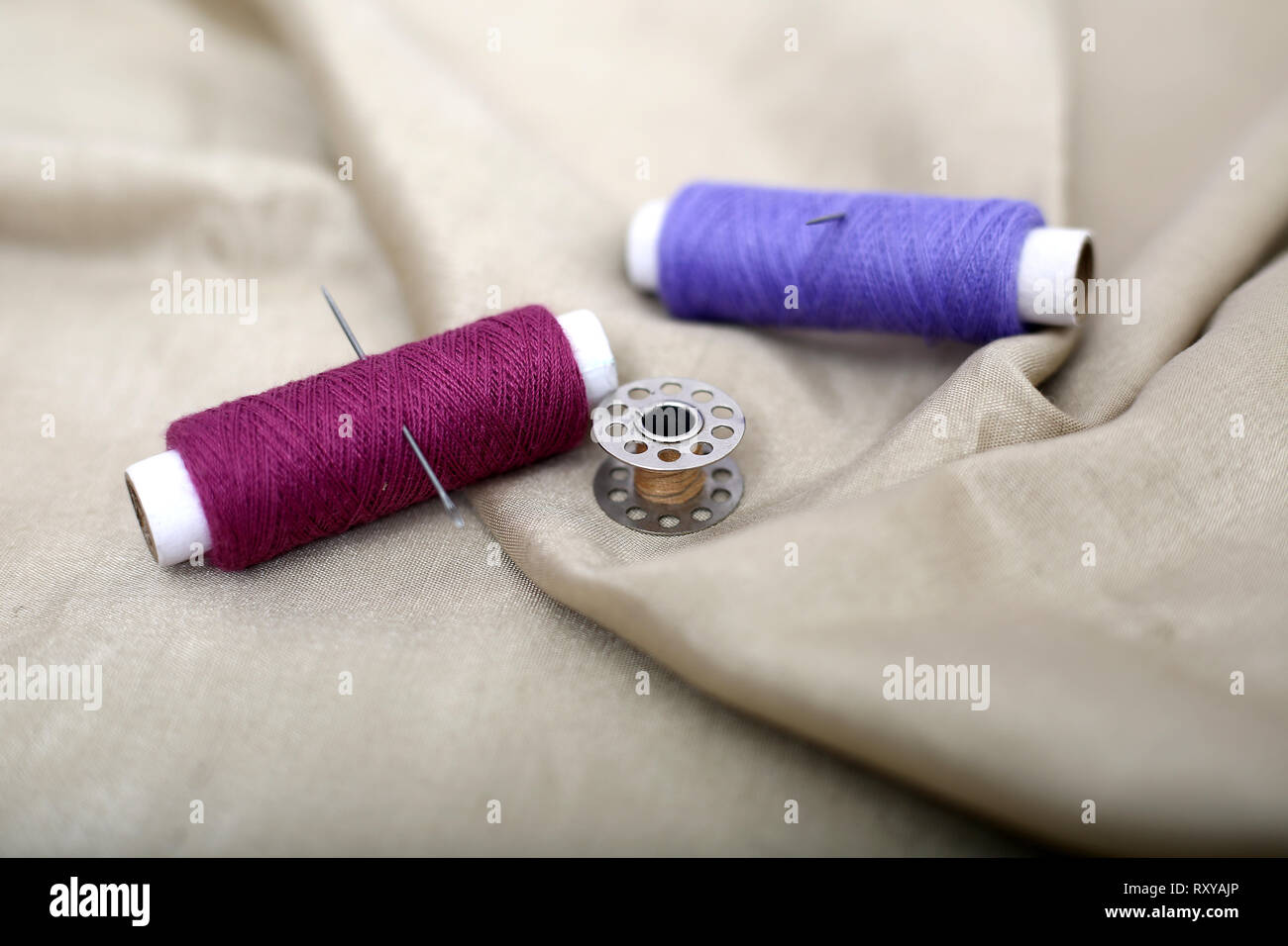 Picture of two thread and bobbin on the cloth Stock Photo - Alamy