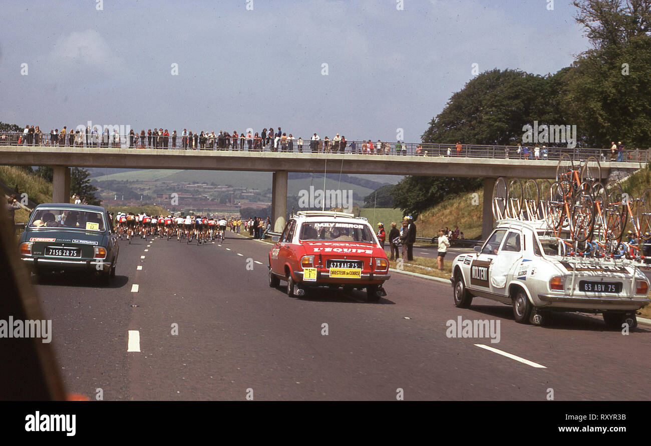 1974 Tour de France, British stage, cyclists going up the Plymouth by-pass, followed by press and support Peugeot cars and watched by spectators on a bridge. Stock Photo