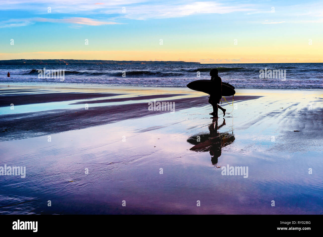 Couple with surfboards at sunset ocean coast, Bali, Indonesia Stock