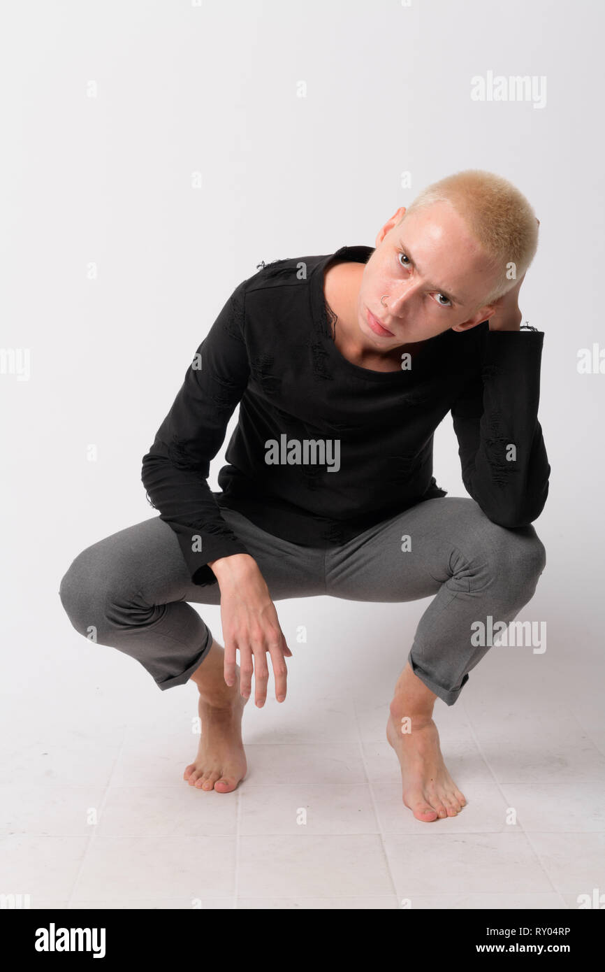 Full body shot of young handsome androgynous man crouching Stock Photo ...