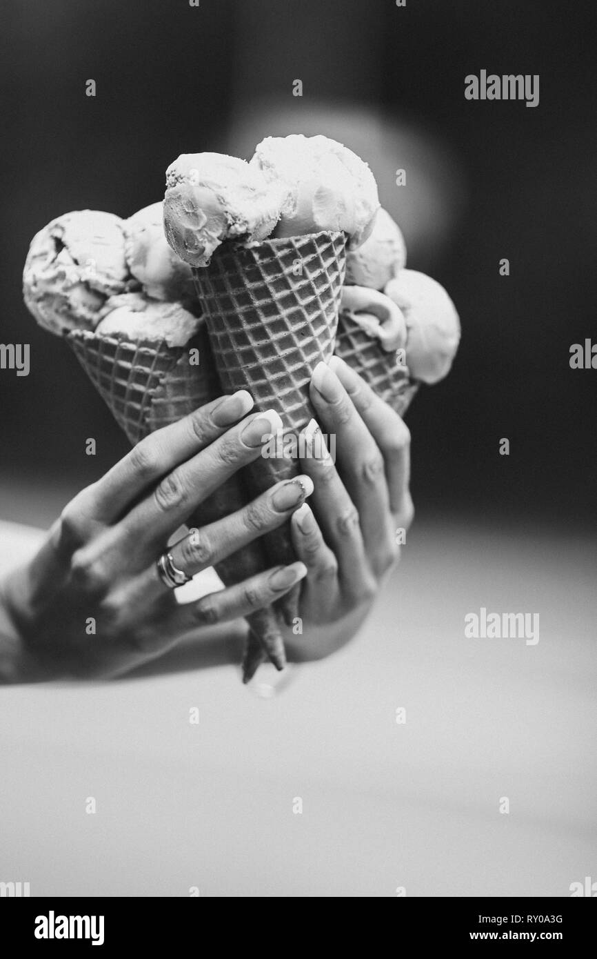 Crop of woman's hand holding delicious colorful ice cream. Stock Photo