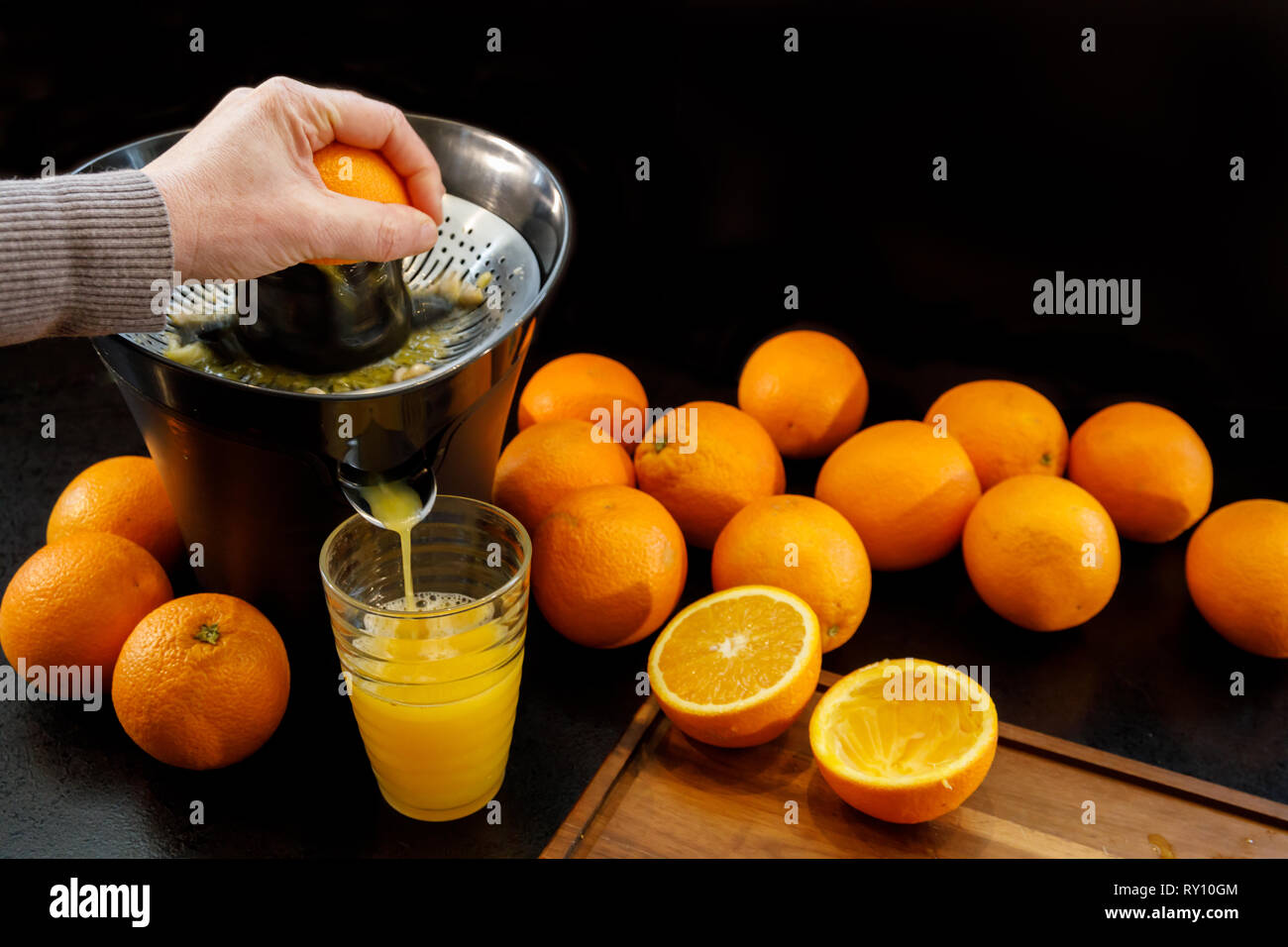Juicing a fresh and healthy orange. Healthy lifestyle concept. Stock Photo